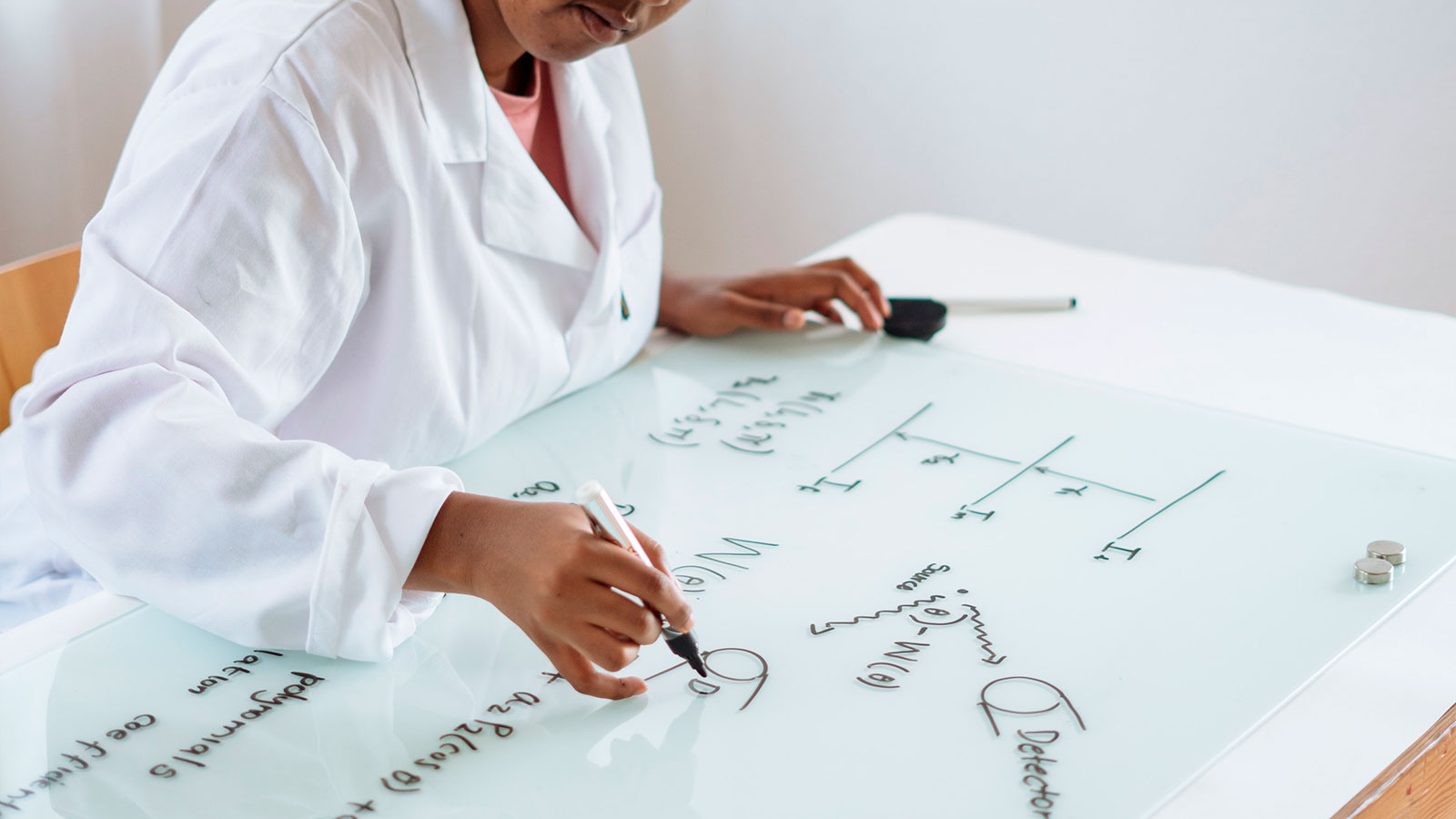 A scientist working out equations on a whiteboard